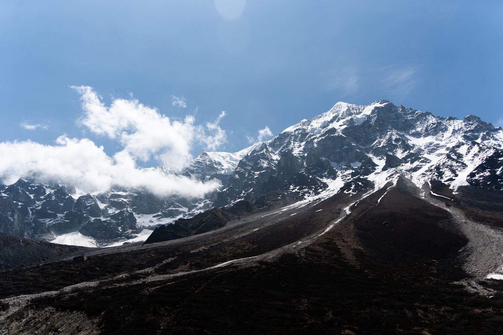 Snow-capped mountain range under clouds
