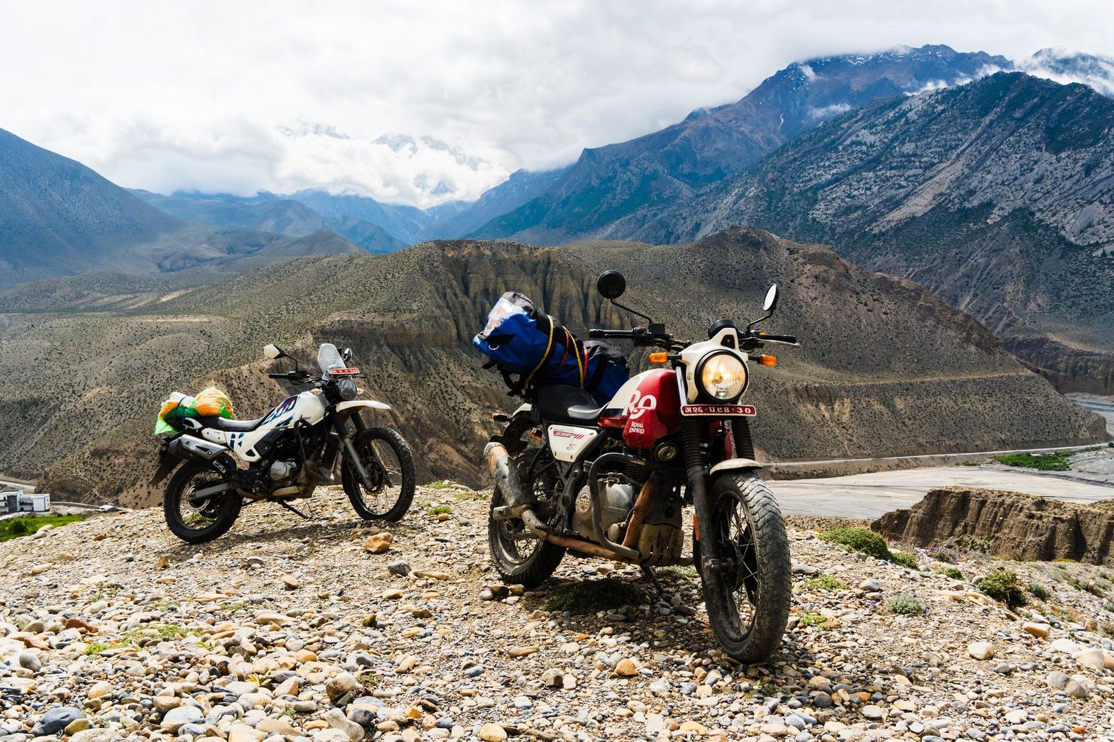 Two motorbikes parked above a mountain valley