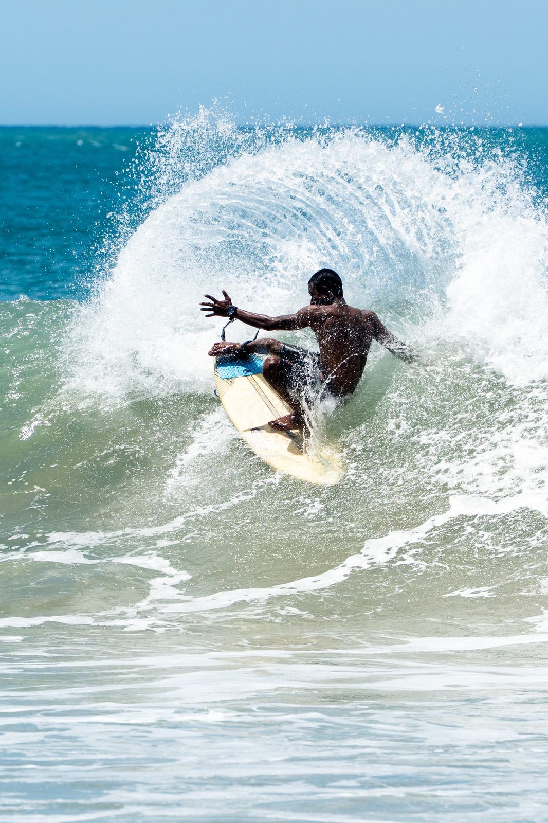 Surfer carving hard, spray arcing overhead