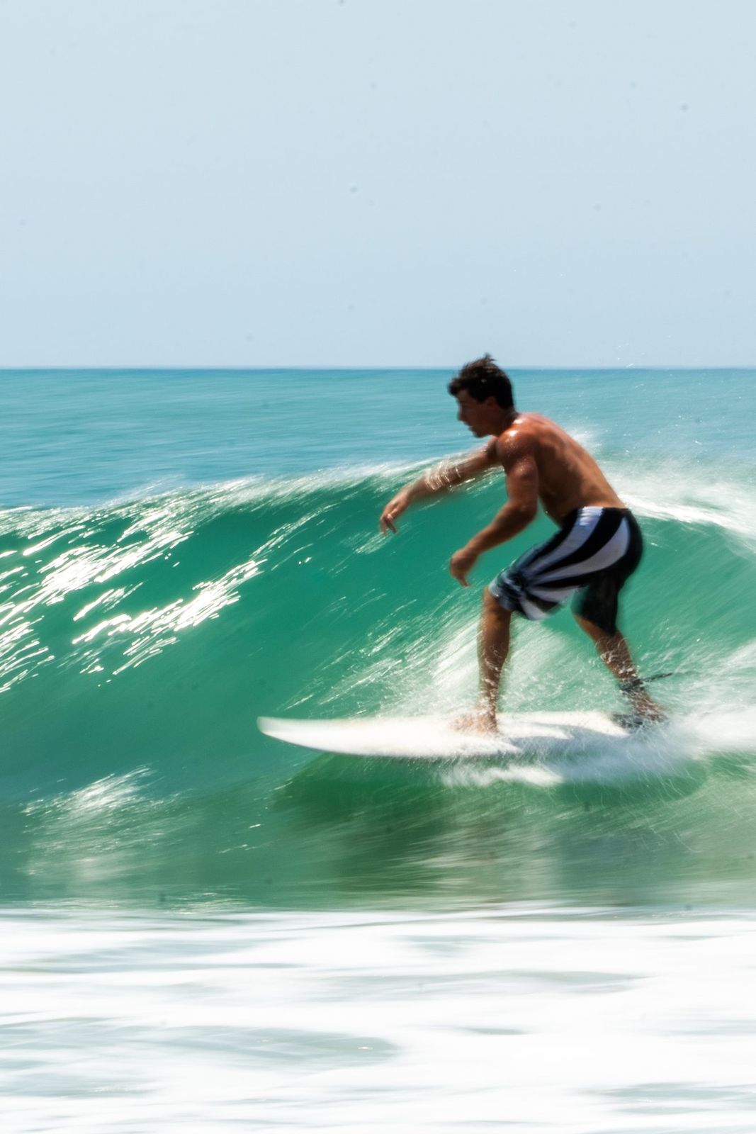 Surfer on a green wave with motion blur