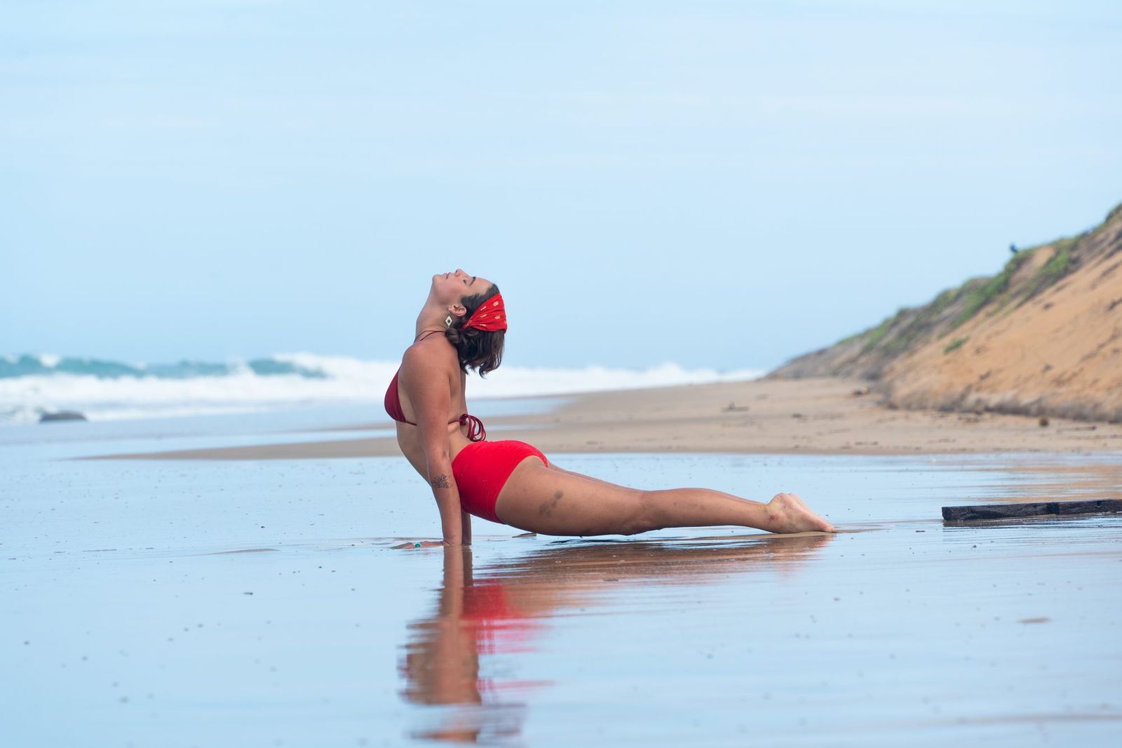 Upward dog pose on a wet beach