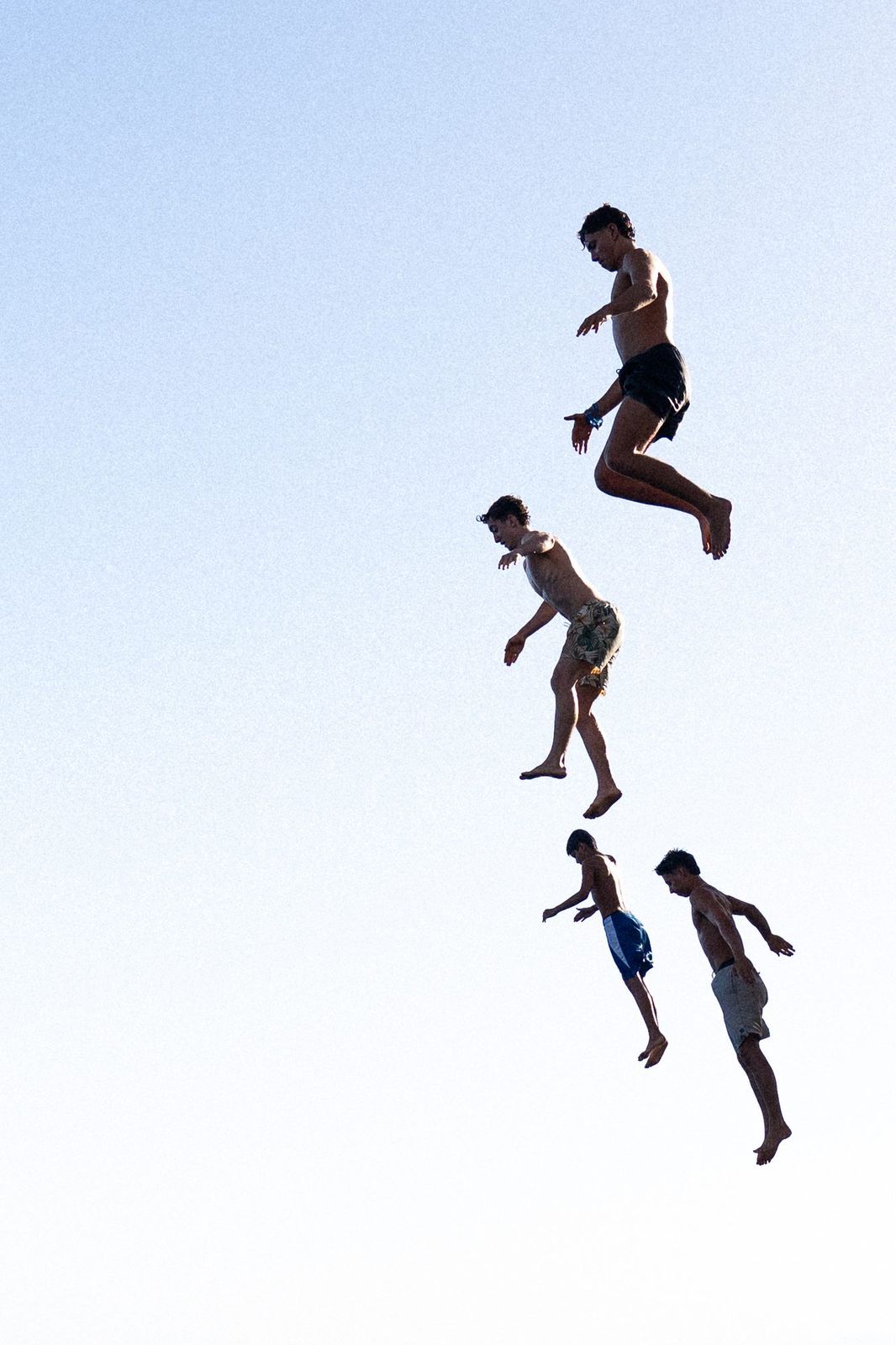 Four cliff jumpers in mid-air