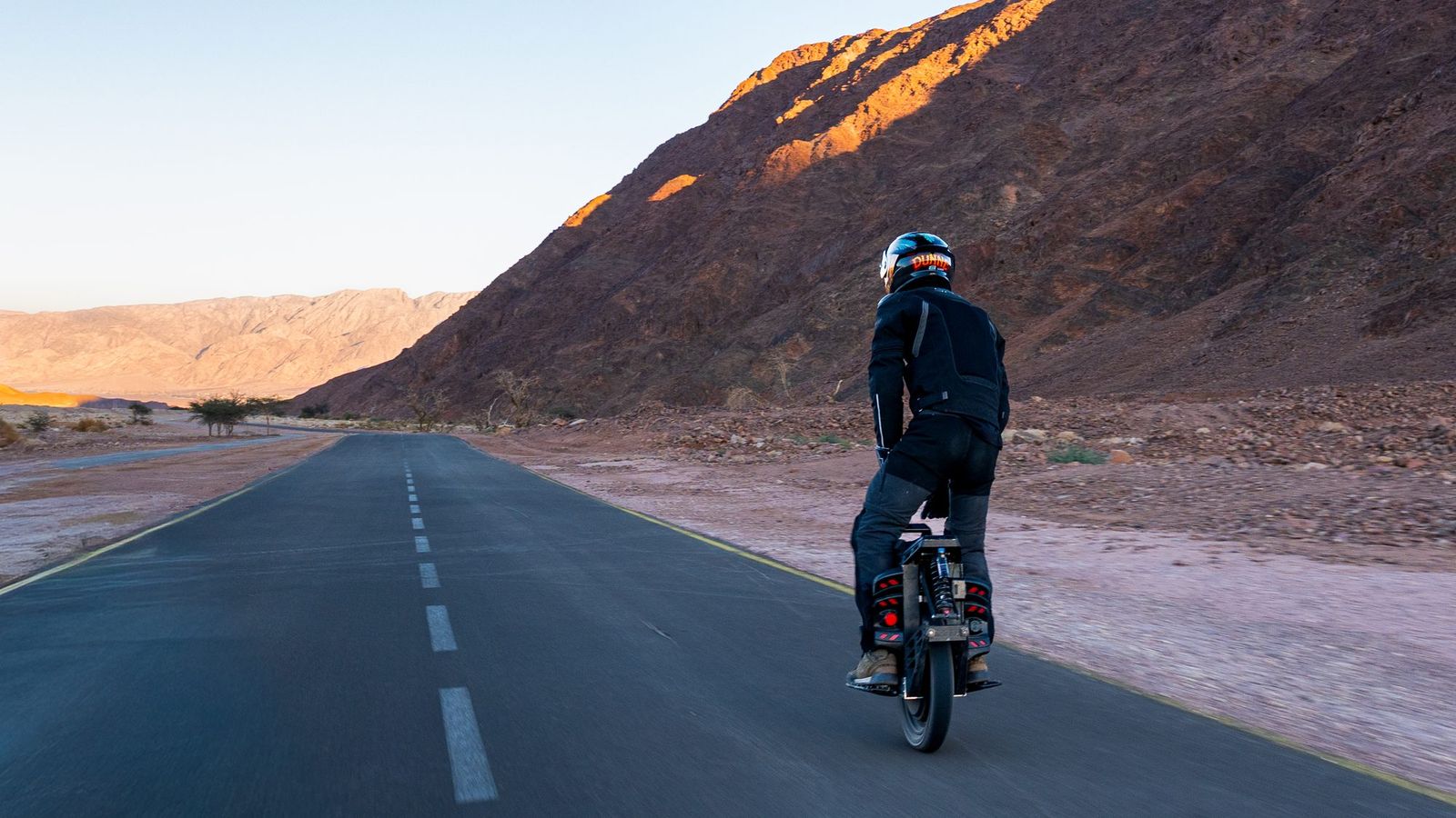 Rider on a desert road at dusk